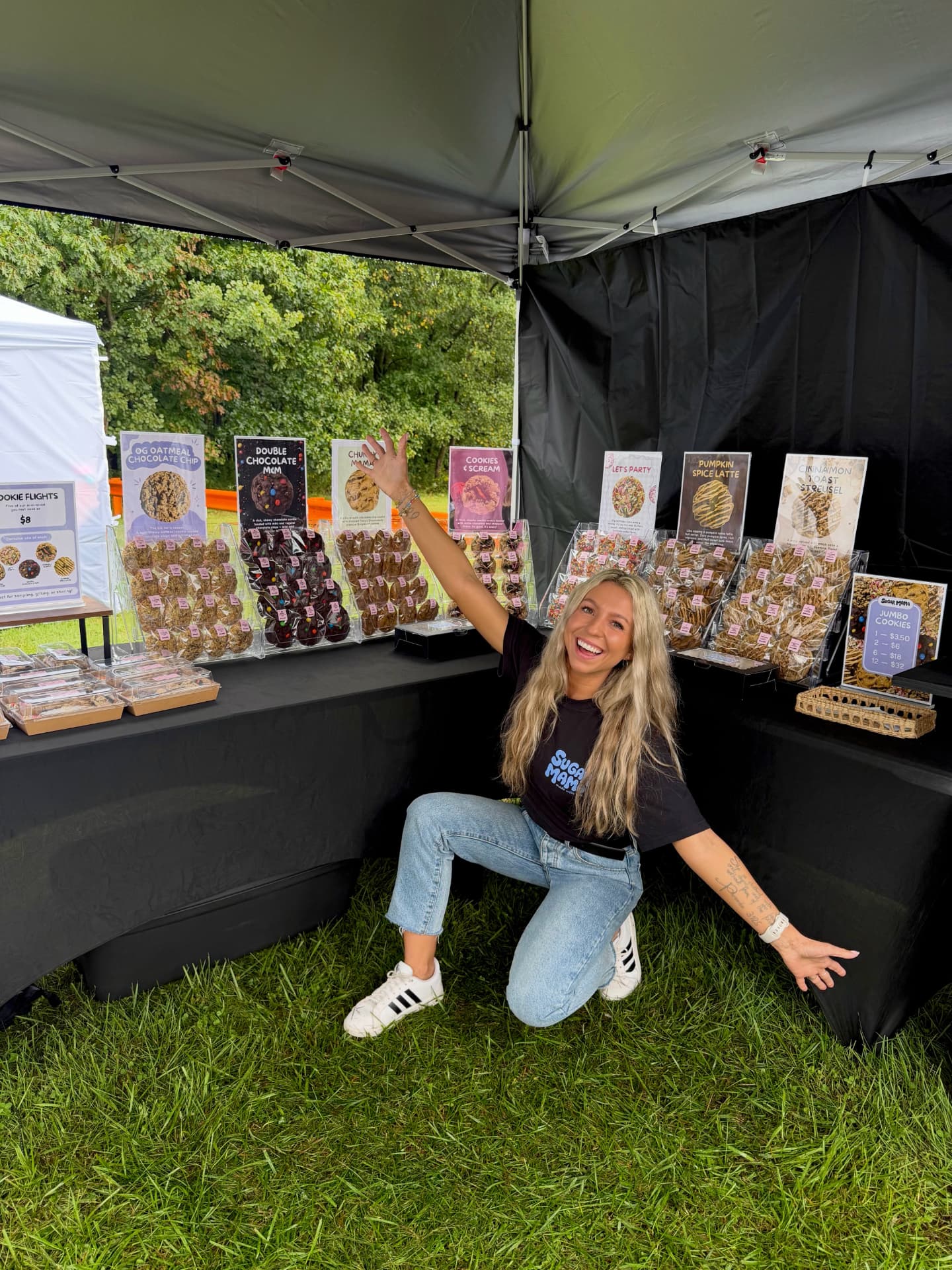 Sara at a Sugar Mama market booth with her cookie display