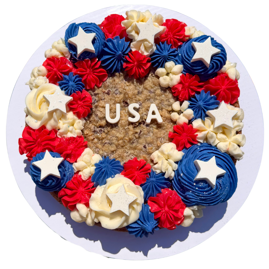Round Sugar Mama cookie cake piped in red, white and blue buttercream with USA lettering